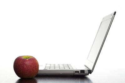 Apple Education Discount on Laptop Sideways On With A Fresh Red Apple In An Education Concept
