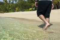 Man walking through shallow surf