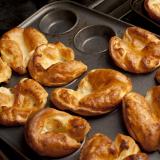 Man removing Yorkshire puddings from a baking tray