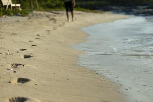 Man walking on a beach with footprints