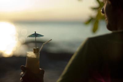 Man with cocktail at sunset