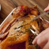 Man carving a delicious brown roast chicken