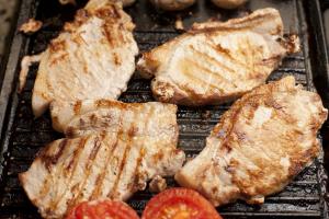 Grilled pork chops and tomatoes on a griddle
