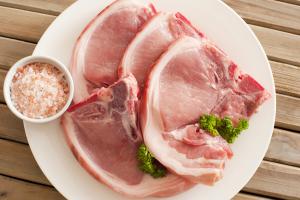 Raw pork cutlets with their rind